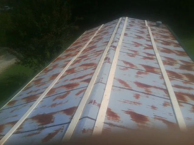Rusted metal roof panels with new wood purlins before replacement — Storm Damage Roof Repair in Martinsville by Roofing Brothers