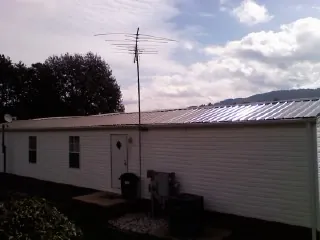 New metal roof on a single wide mobile home with a TV antenna in Martinsville