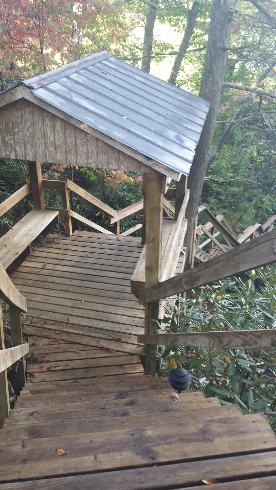 Metal roofed shelter over wooden steps on a wooded walkway — Skylight Repair & Installation work by our crew in Martinsville