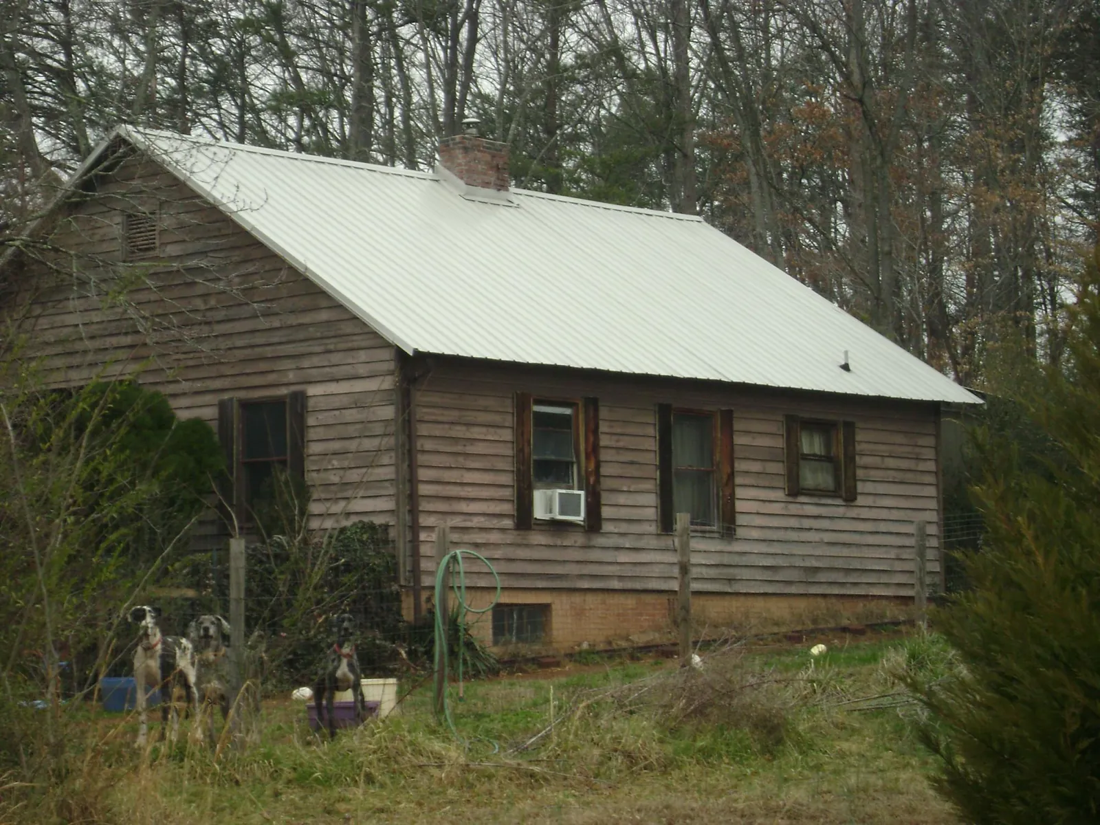 White metal roof on an old wood sided farmhouse, from a Asphalt Shingle Roof Repair job in Martinsville
